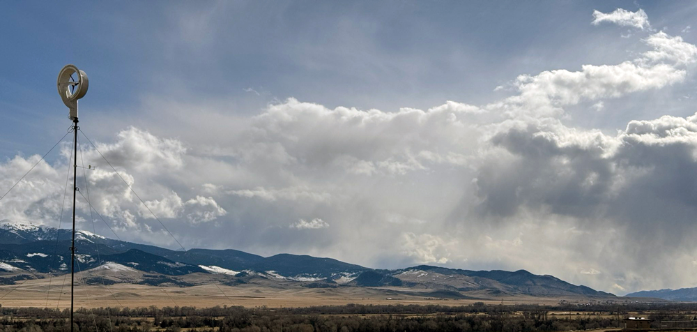 A cloudy sky over a valleyDescription automatically generated